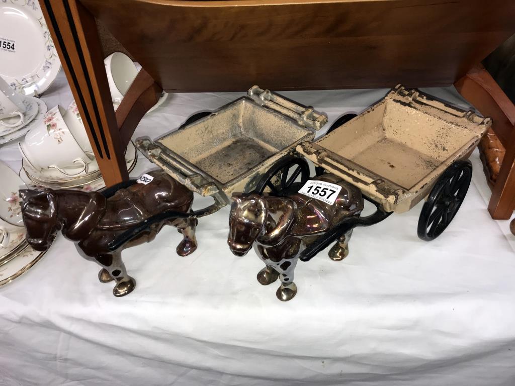 A pair of cast iron horse and cart ornaments