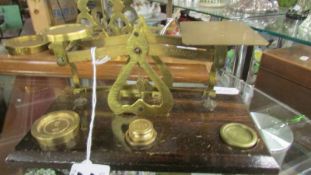 A set of brass postal scales with weights.