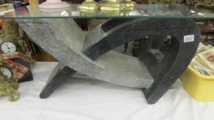 A marble based coffee table with glass top.