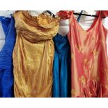 Four evening gowns in varying sizes and designs with lots of frills,