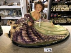 A large vintage painted plaster figurine of a lady in crinoline dress with dog.