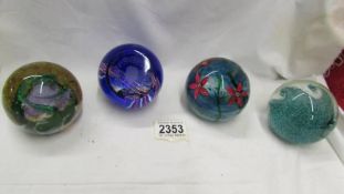 Four Caithness glass paperweights.