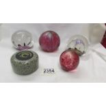 Two Selkirk glass paperweights, 2 others and a granite curling stone paperweight.