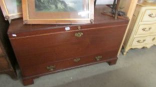 A large mahogany trunk with drawer.