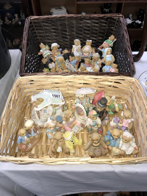 A collection of cherished teddies in 2 wicker baskets approximately 30 bears in total