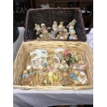 A collection of cherished teddies in 2 wicker baskets approximately 30 bears in total
