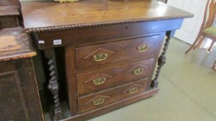 An oak three drawer chest with side columns.