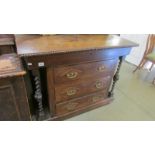 An oak three drawer chest with side columns.