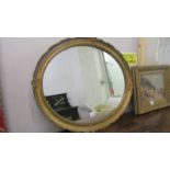 An oval gilt framed mirror.