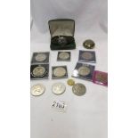 A quantity of commemorative coins, a wrist watch and a snuff box.