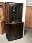 A dark oak corner cabinet with leaded glass door, 90 cm wide x 179 cm high.