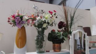 A quantity of silk flowers in vases.