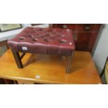 A good quality red leather foot stool.