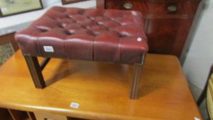 A good quality red leather foot stool.