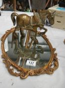 An oval cast mirror and a heavy cast brass horse.