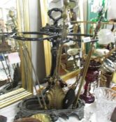 A cast iron stick stand and a quantity of brass fire irons,