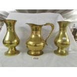 A pair of heavy brass vases and a brass jug.