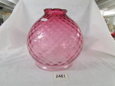 A cranberry glass lamp shade, in good condition.