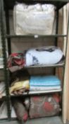 Four shelves of assorted bedding including quilts. (Collect only).