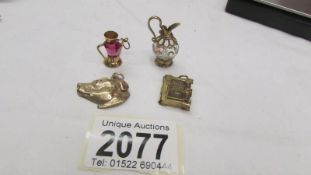 Four assorted 9ct gold charms, 21 grams total.