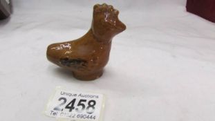 An antique Staffordshire bird caller in the form of a hen.