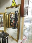 A gilt framed bevel edged mirror.