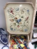 A vintage folding fire screen/coffee table with painted floral decoration