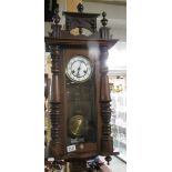 A wall clock with pendulum and key. in working order.