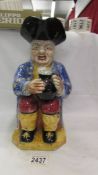 A large Staffordshire Toby figure with hat.