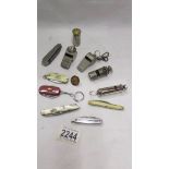 A mixed lot of old whistles, penknives etc.