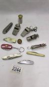 A mixed lot of old whistles, penknives etc.