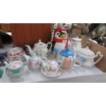 A Penguin biscuit jar and 8 assorted teapots.