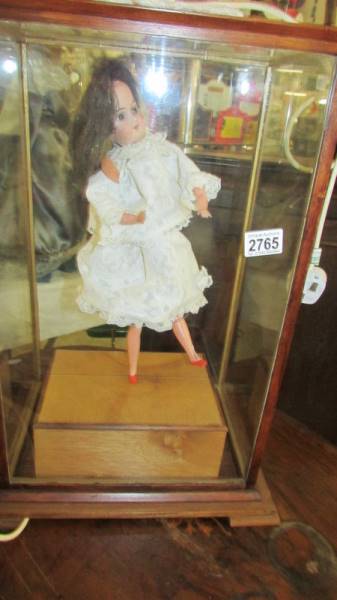 A cased electrically operated automaton doll.