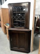 A dark oak corner cabinet with leaded glass door, 90 cm wide x 179 cm high.