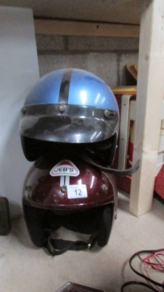 Two classic 'open face' motor cycle helmets.
