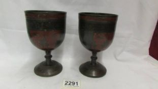 A pair of heavy metal goblets (possibly bronze).