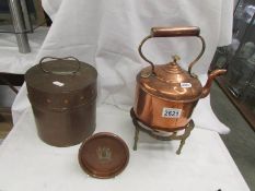 A copper kettle on trivet and 2 other items.