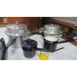 Two pressure cookers and three enamel pans.