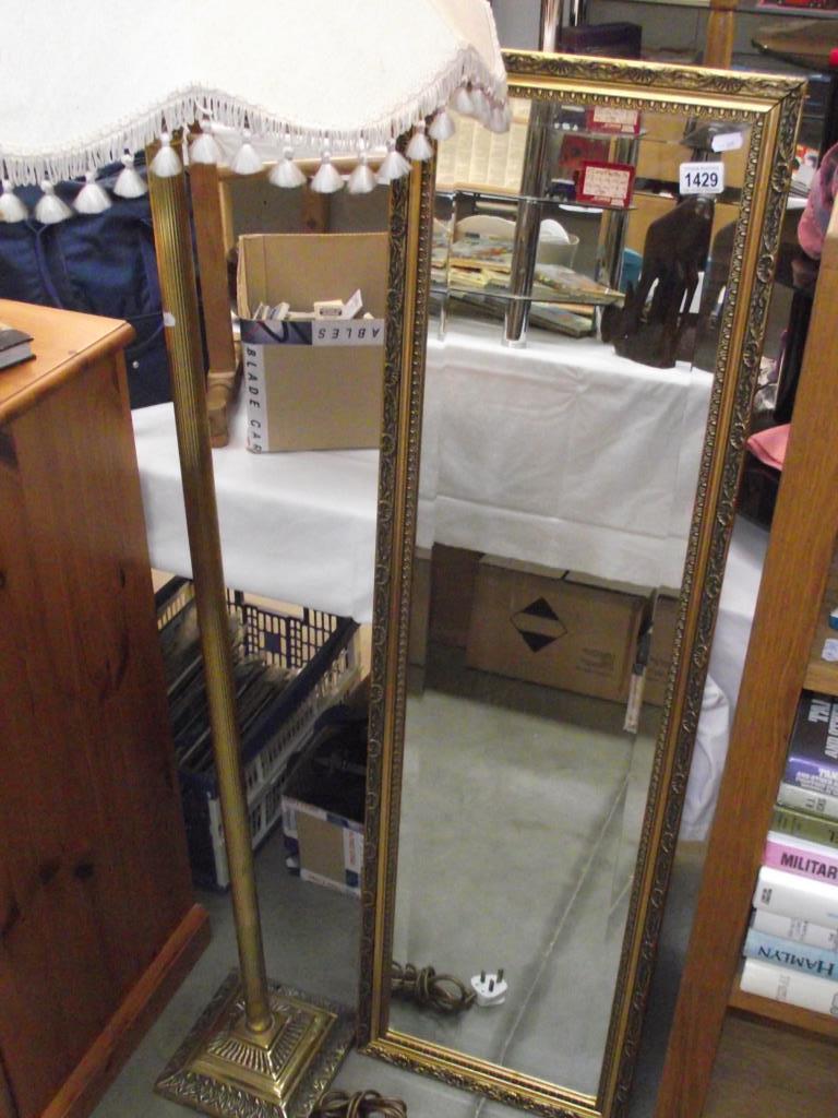 A gilt standard lamp and shade and a bevel edged wall mirror