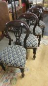 A set of four dark wood dining chairs,