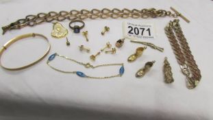 A mixed lot of yellow metal jewellery including earrings, charms, bracelets etc.