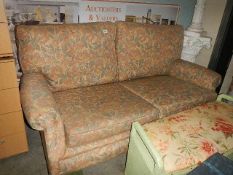 A two seat sofa on brass castors. (Collect only).