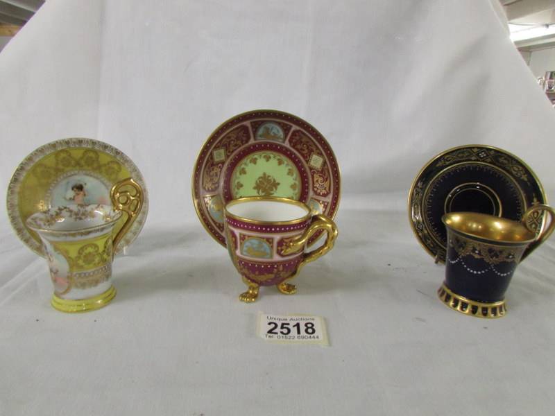 Three hand painted Vienna tea cups and saucers, in good condition.