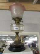 A Victorian oil lamp on pot base with glass font and complete with shade.