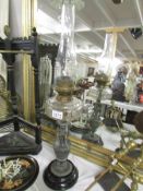 A Victorian oil lamp with urn base, glass font and chimney.