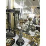 A Victorian oil lamp with urn base, glass font and chimney.