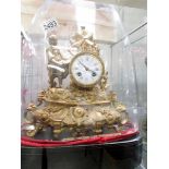A French gilded mantel clock under glass dome.