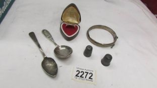 A silver ring, a silver bangle, a silver caddy spoon, a silver teaspoon and 2 thimbles.