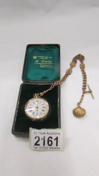 A 9ct gold ladies fob watch on an ornate 9ct gold Albertine, in working order.