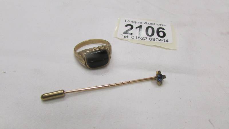 A 9ct gold onyx ring size U and a 9ct gold stick pin.